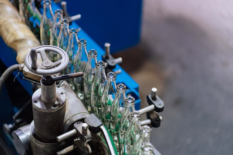 Close-up of glass bottling machinery in action, showcasing industrial precision.